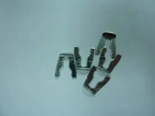 Mehrere silberne Metallklammern liegen auf einem weißen Hintergrund. Diese könnten Teil eines Produkts von Remeha sein.